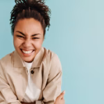 enthusiastic-woman-laughing-turquoise-wall_197531-19734